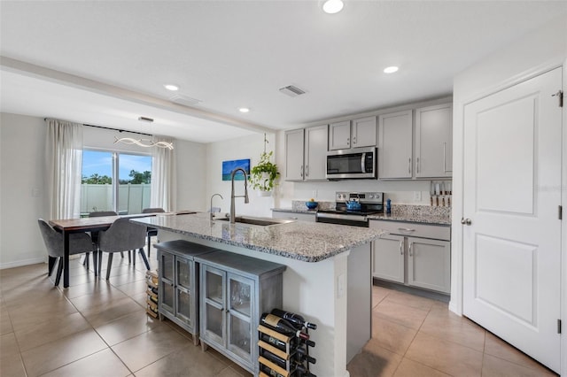 kitchen with a sink, visible vents, appliances with stainless steel finishes, and gray cabinetry