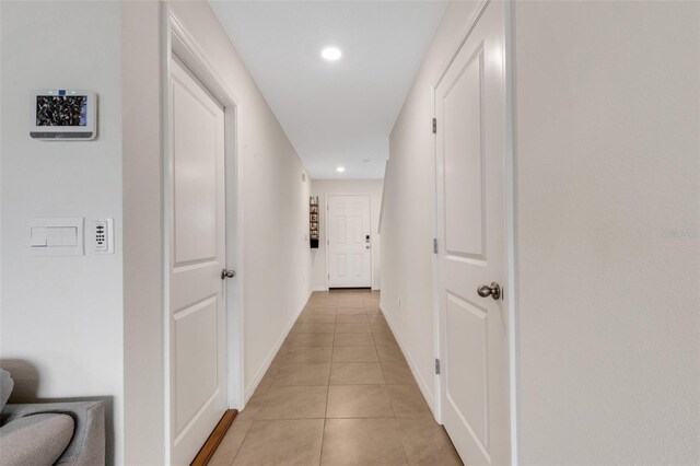 corridor with light tile patterned floors, recessed lighting, and baseboards