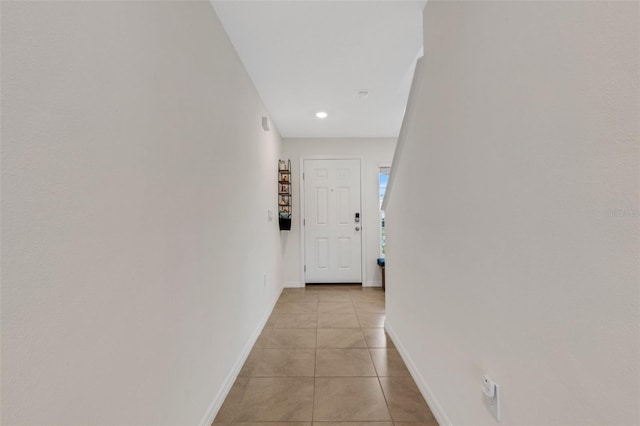 hall with light tile patterned floors, baseboards, and recessed lighting