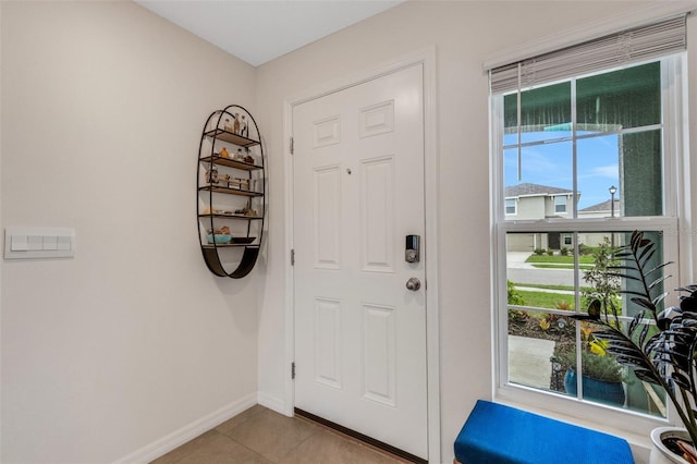 entrance foyer featuring baseboards and tile patterned flooring