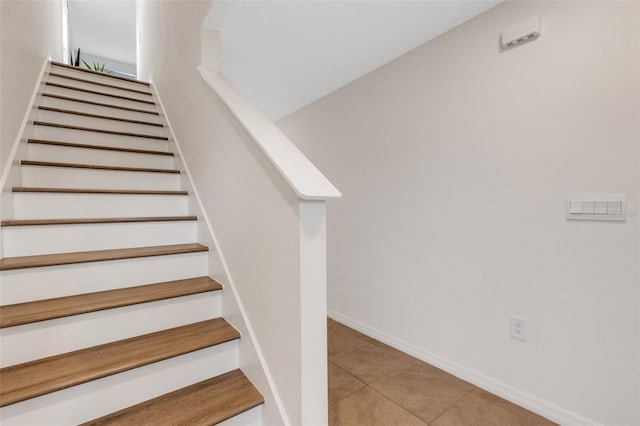 staircase featuring tile patterned flooring and baseboards