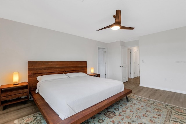 bedroom with wood finished floors, baseboards, and ceiling fan