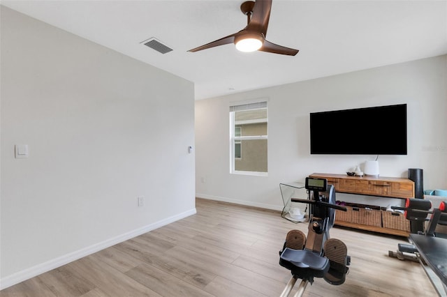 workout room featuring light wood finished floors, visible vents, a ceiling fan, and baseboards