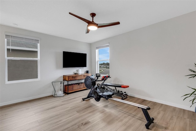 exercise room with baseboards, wood finished floors, and a ceiling fan