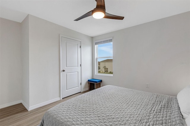 bedroom featuring a ceiling fan, light wood-style floors, and baseboards