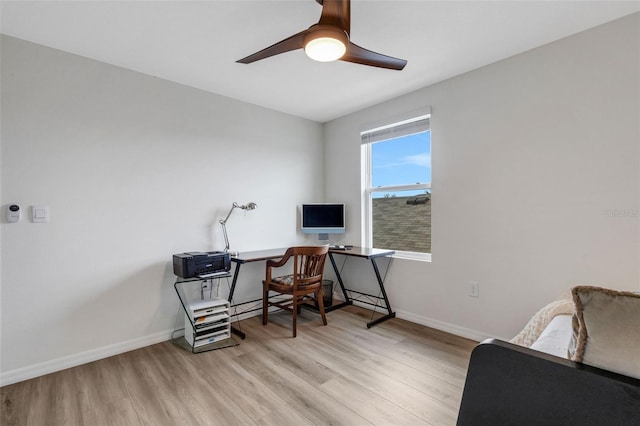 office with light wood-style flooring, a ceiling fan, and baseboards