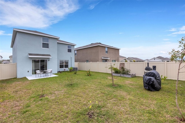 rear view of house with a patio area, a lawn, and a fenced backyard