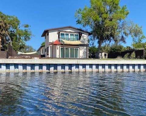 rear view of house featuring a water view