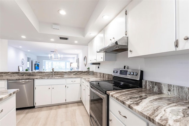 kitchen featuring visible vents, a sink, appliances with stainless steel finishes, under cabinet range hood, and white cabinetry