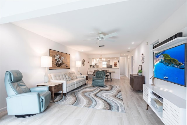 living room featuring recessed lighting, ceiling fan with notable chandelier, and wood tiled floor