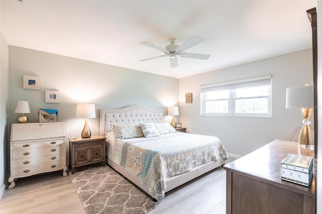 bedroom with baseboards, a ceiling fan, and light wood-style floors