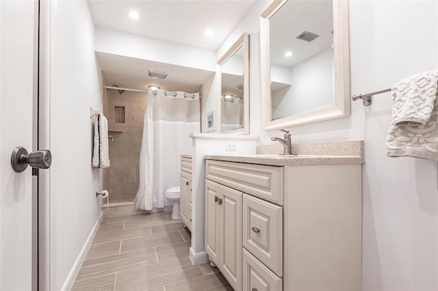 bathroom featuring visible vents, a shower with curtain, toilet, baseboards, and vanity