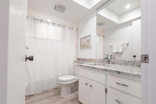 full bathroom featuring visible vents, curtained shower, toilet, wood finished floors, and vanity