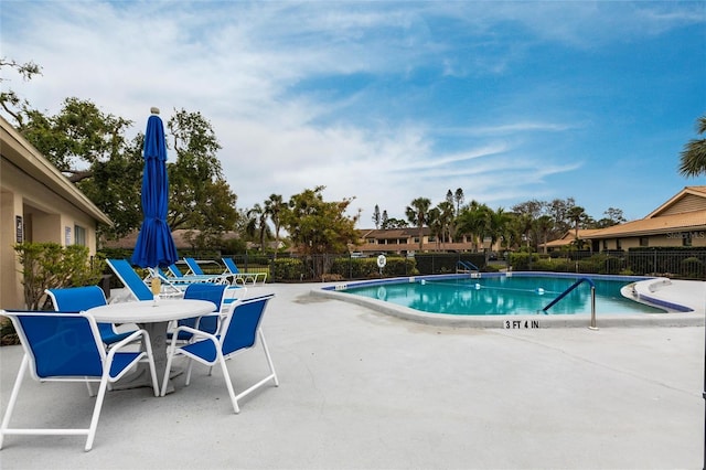 community pool featuring a patio area and fence