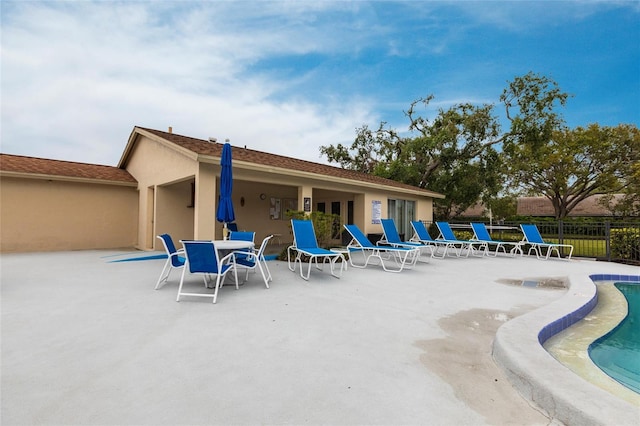 exterior space with a community pool and fence