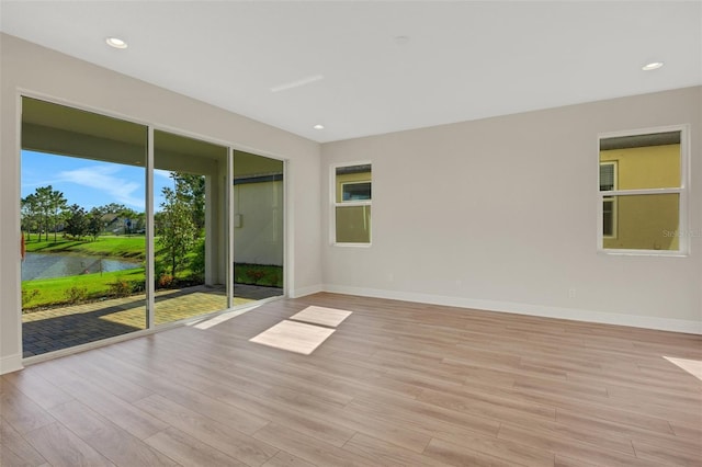 unfurnished room featuring recessed lighting, light wood-type flooring, and baseboards