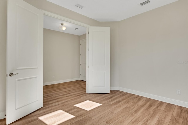 empty room with visible vents, baseboards, and light wood-style flooring