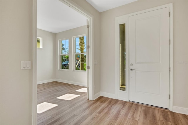 foyer entrance with light wood finished floors and baseboards