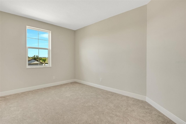 empty room featuring baseboards and carpet