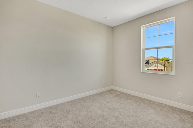 unfurnished room featuring carpet and baseboards