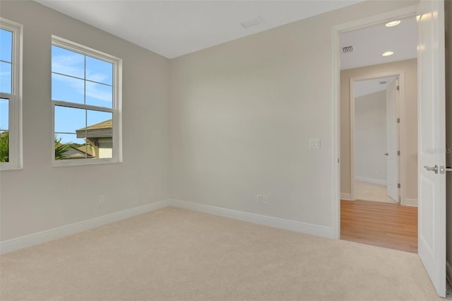 empty room with visible vents, carpet, and baseboards