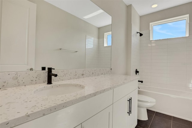 full bathroom with tile patterned flooring, a healthy amount of sunlight, toilet, and washtub / shower combination