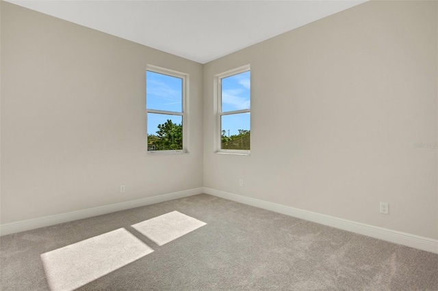 unfurnished room with baseboards and carpet flooring