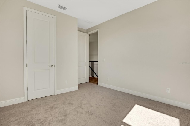 unfurnished bedroom featuring carpet, visible vents, and baseboards