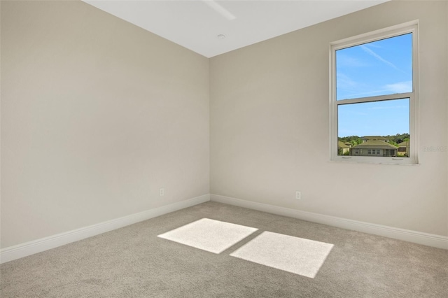 spare room featuring carpet flooring and baseboards