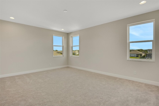 unfurnished room with recessed lighting, light colored carpet, and baseboards