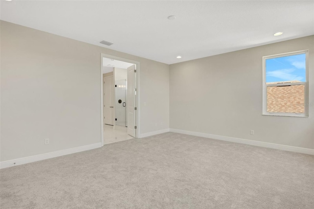 spare room featuring recessed lighting, visible vents, light colored carpet, and baseboards