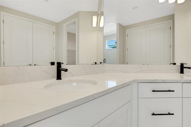 full bath featuring double vanity, visible vents, and a sink