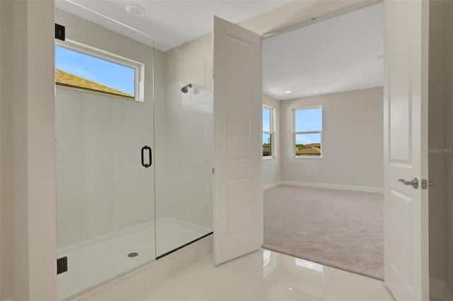 bathroom with tile patterned floors, baseboards, and a stall shower