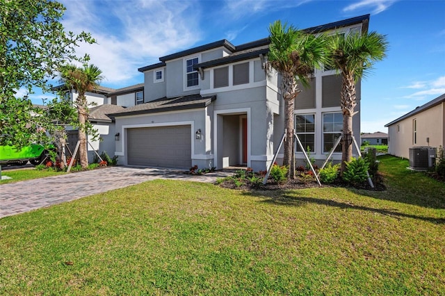 view of front of home featuring stucco siding, an attached garage, decorative driveway, and a front yard