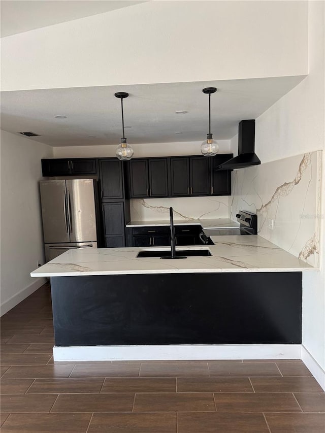 kitchen featuring wood tiled floor, freestanding refrigerator, a sink, electric stove, and wall chimney range hood