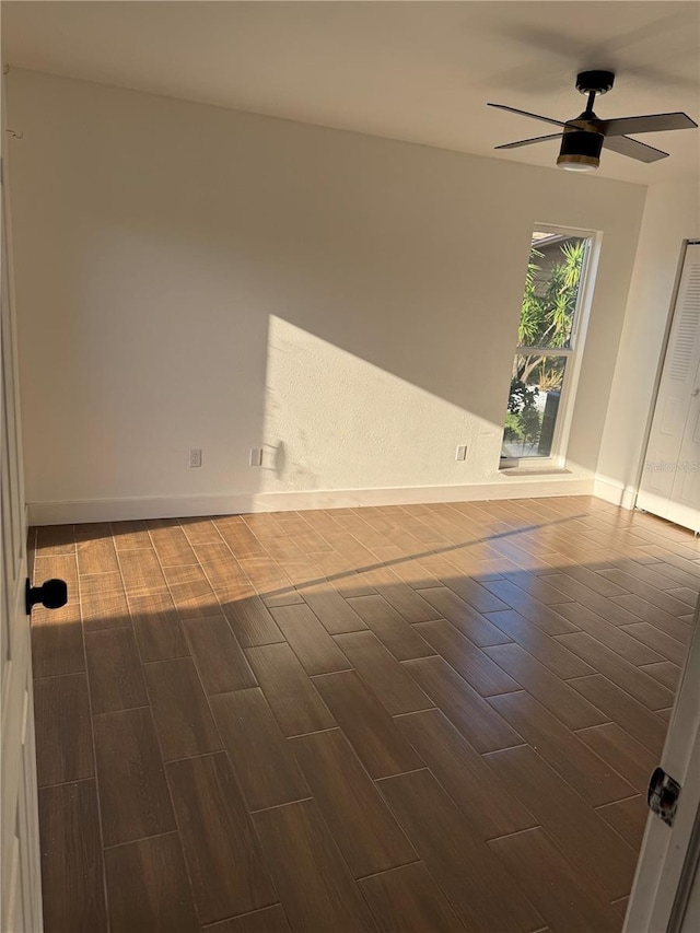 spare room with a ceiling fan, baseboards, and wood finish floors