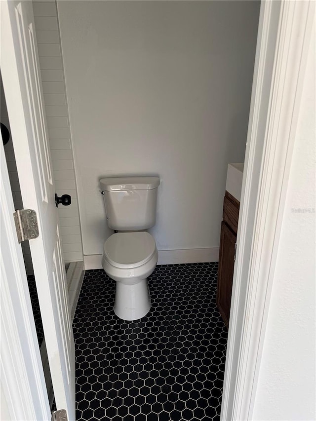 bathroom featuring tile patterned flooring, toilet, vanity, and baseboards