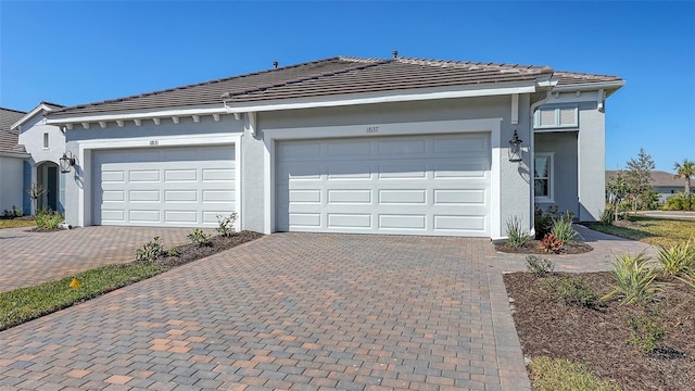 ranch-style home with stucco siding, a tiled roof, and decorative driveway