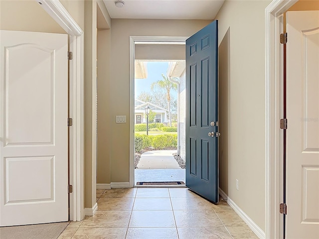 entrance foyer with light tile patterned floors and baseboards