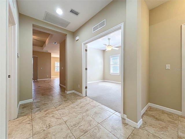 hall featuring visible vents, baseboards, and attic access