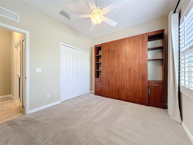 unfurnished bedroom featuring light carpet, visible vents, and a closet