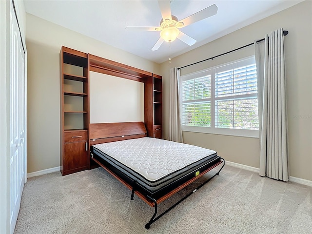 bedroom featuring light colored carpet, baseboards, and ceiling fan