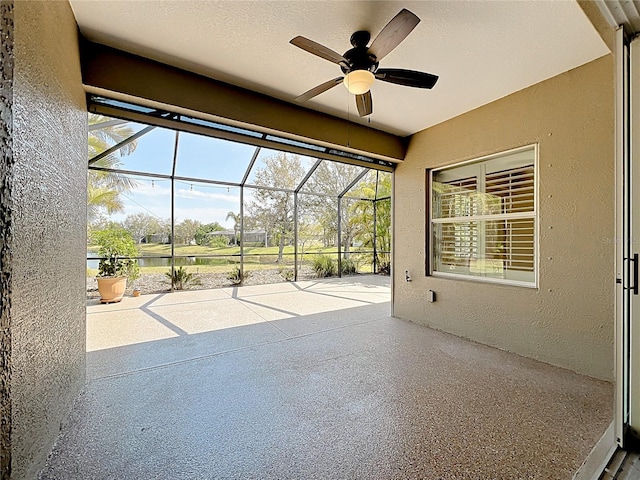 view of patio featuring glass enclosure and a ceiling fan