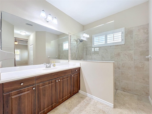 bathroom with vanity, a healthy amount of sunlight, visible vents, and walk in shower