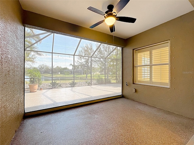 unfurnished sunroom with ceiling fan