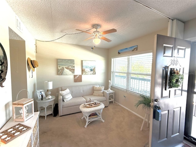 carpeted living room featuring baseboards, a textured ceiling, and a ceiling fan