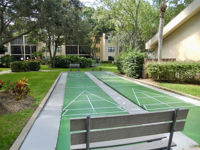 view of property's community featuring a lawn and shuffleboard