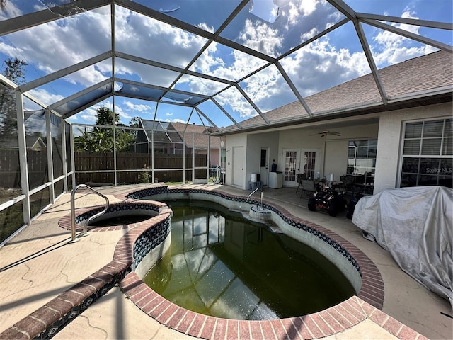 view of swimming pool with a pool with connected hot tub, fence, french doors, a patio area, and a ceiling fan