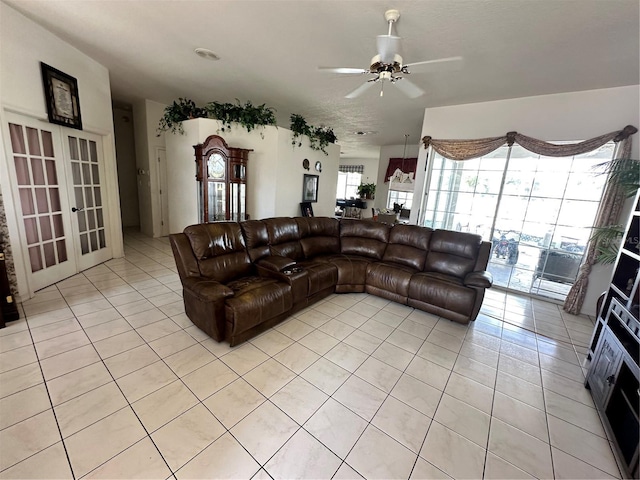 living area with light tile patterned floors, french doors, and a ceiling fan