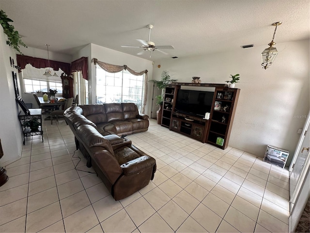 living room with a wealth of natural light, visible vents, a textured ceiling, and light tile patterned floors